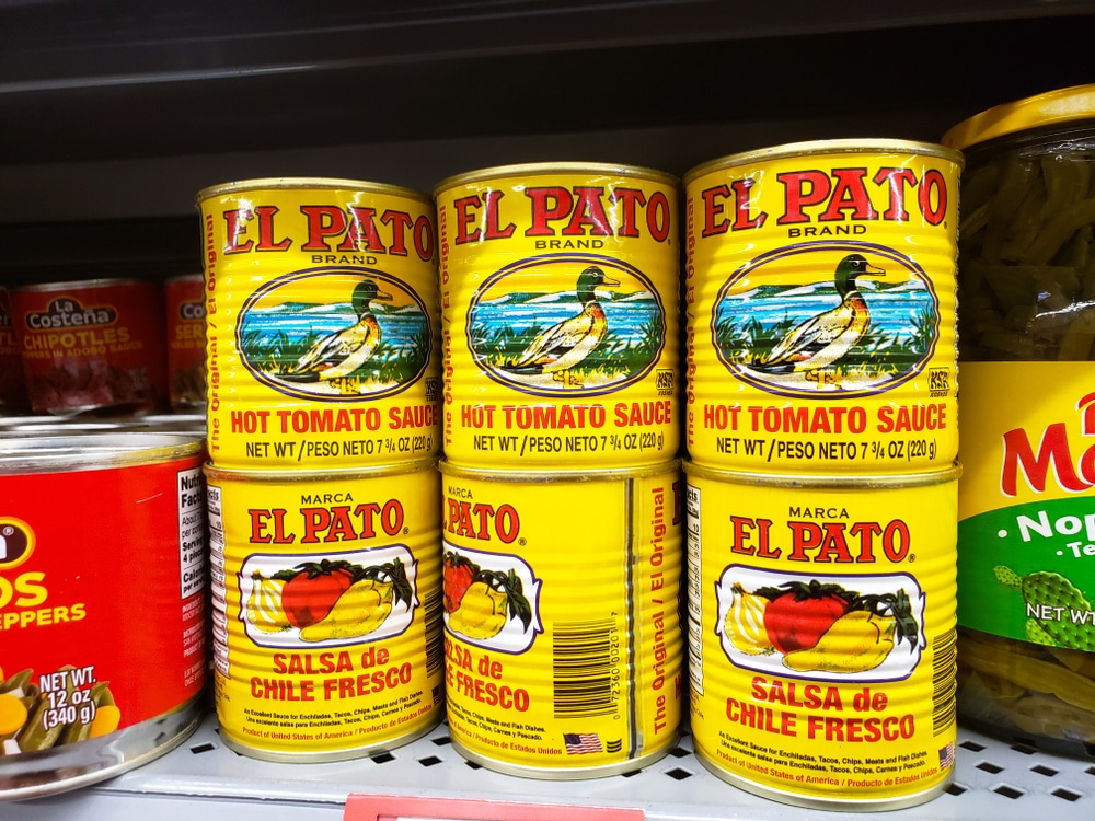 a number of El Pato Sauce cans