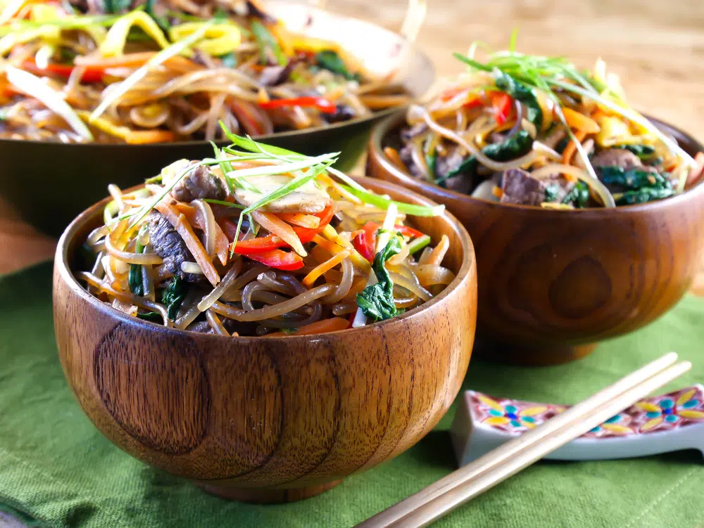 Japchae With Beef And Vegetables In Wooden Bowls