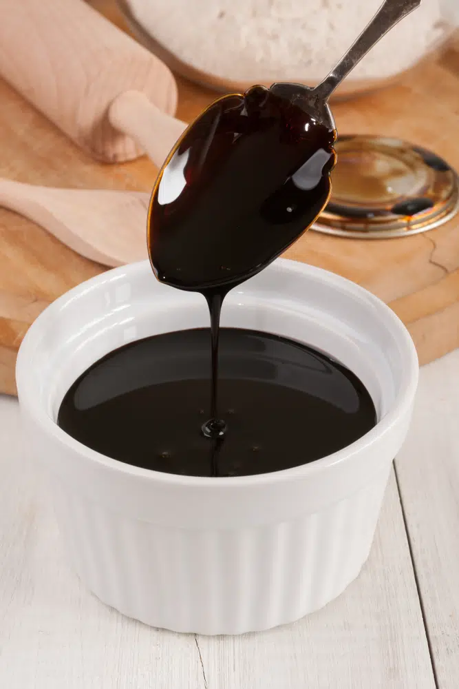 Spoon Dipped In A Baking Dish With Blackstrap Molasses