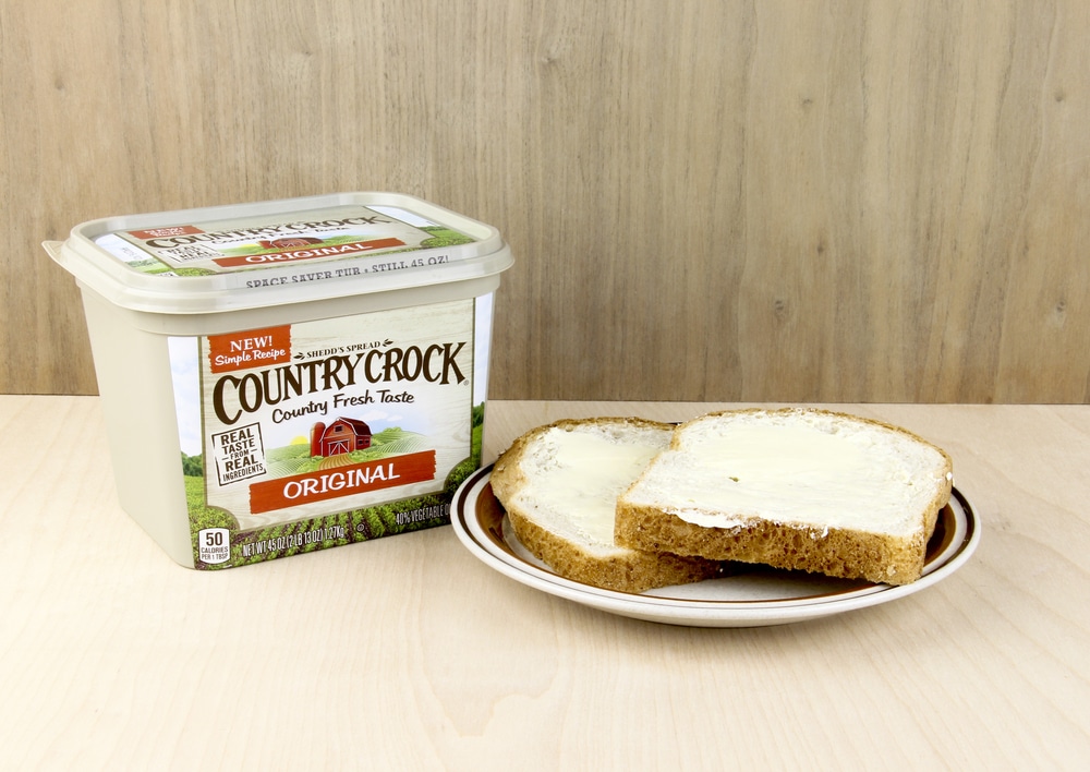 Container Of Country Crock Original Spread And Buttered Bread On A Plate