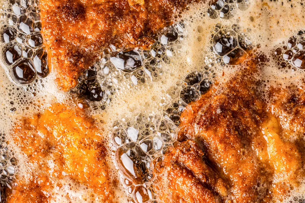 Breaded Chicken Being Deep Fried In Oil