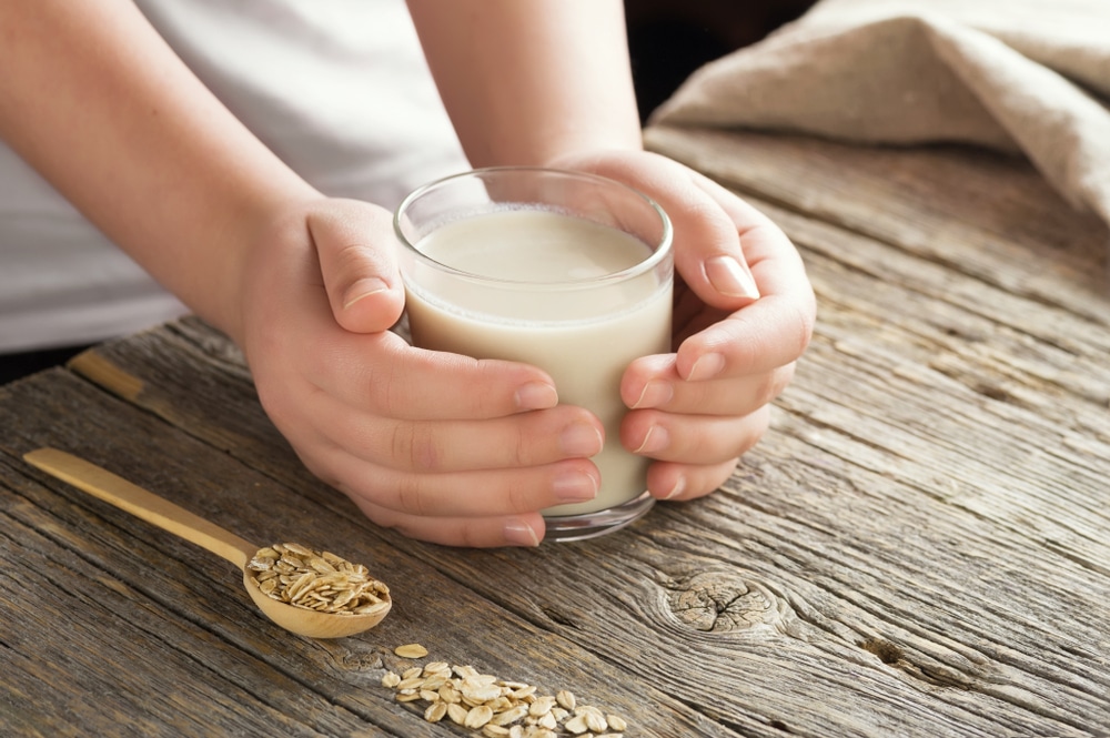 A Person Holding A Glass Of Oat Milk