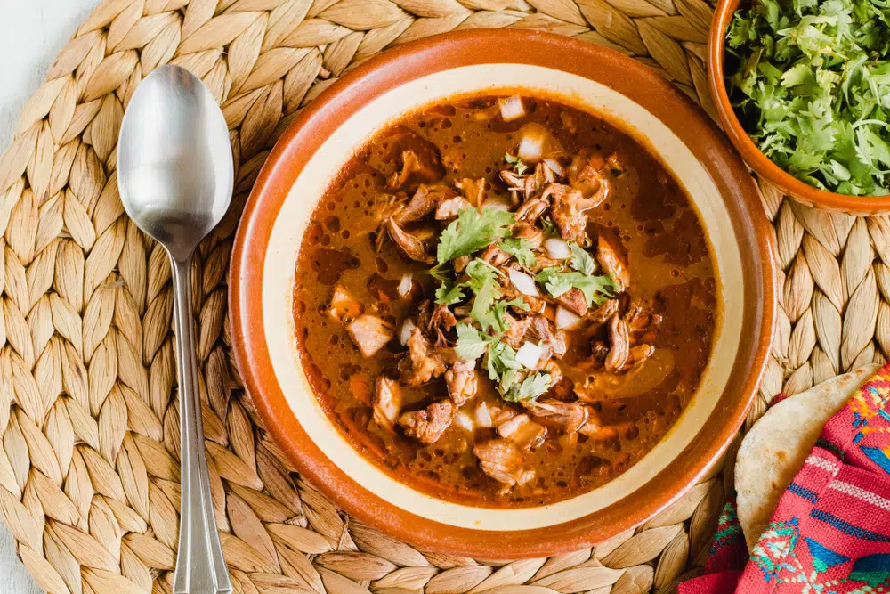 Birria In A Bowl With A Spoon Beside It