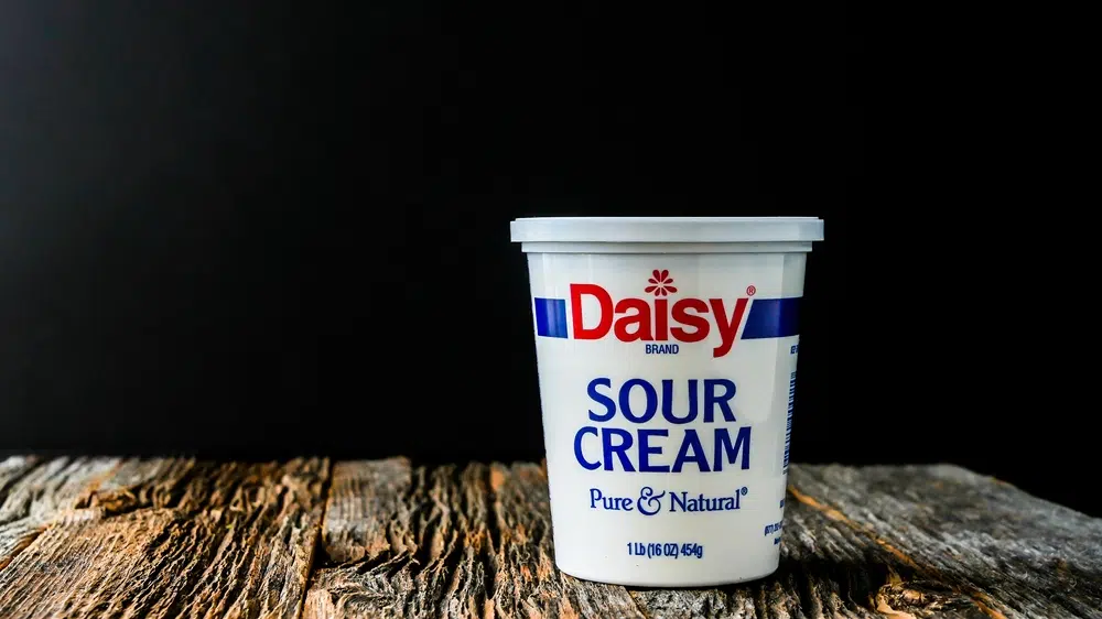Daisy Sour Cream On Rustic Wooden Table With Black Background