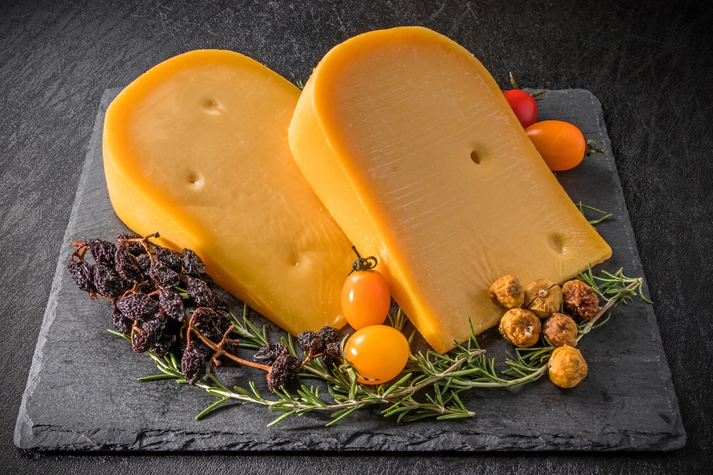 Gouda Cheese Slices On Top Of Stone Board