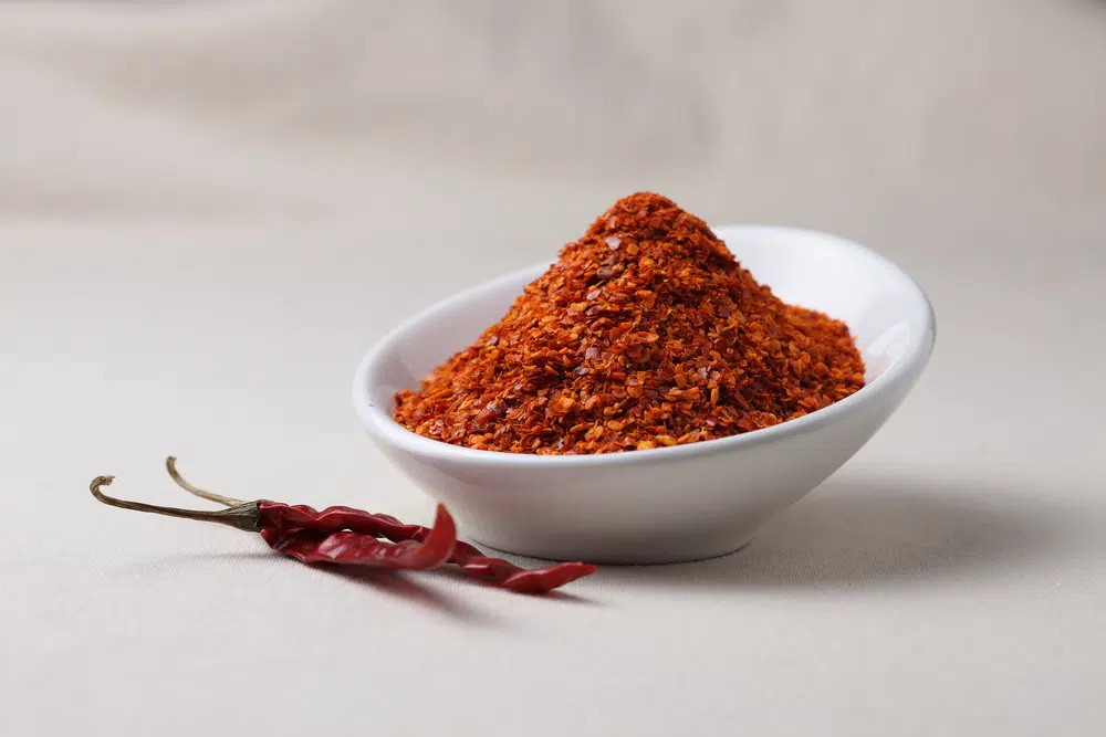 Red Chilli Powder In A Bowl With Dry Red Chilli Peppers