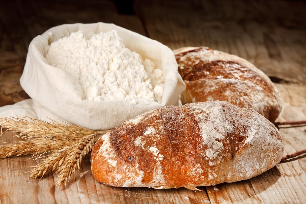Fresh Bread With Wheat Flour On The Table