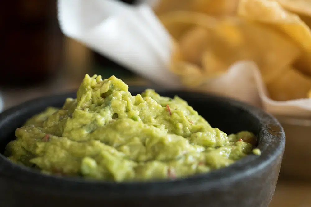 Close Up On Avocado Guacamole In A Black Mortar Bowl