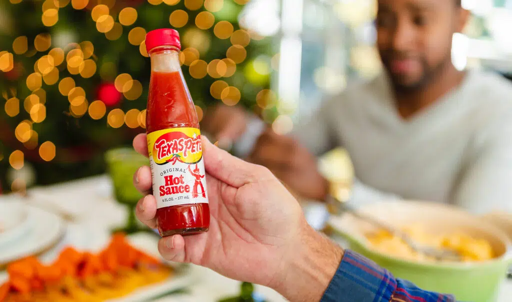 Hand Holding A Bottle Of Texas Pete Hot Sauce