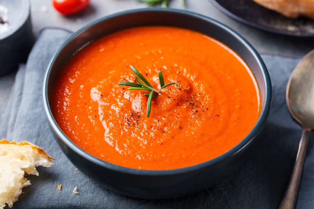 Tomato Soup In A Black Bowl On Grey Stone Background