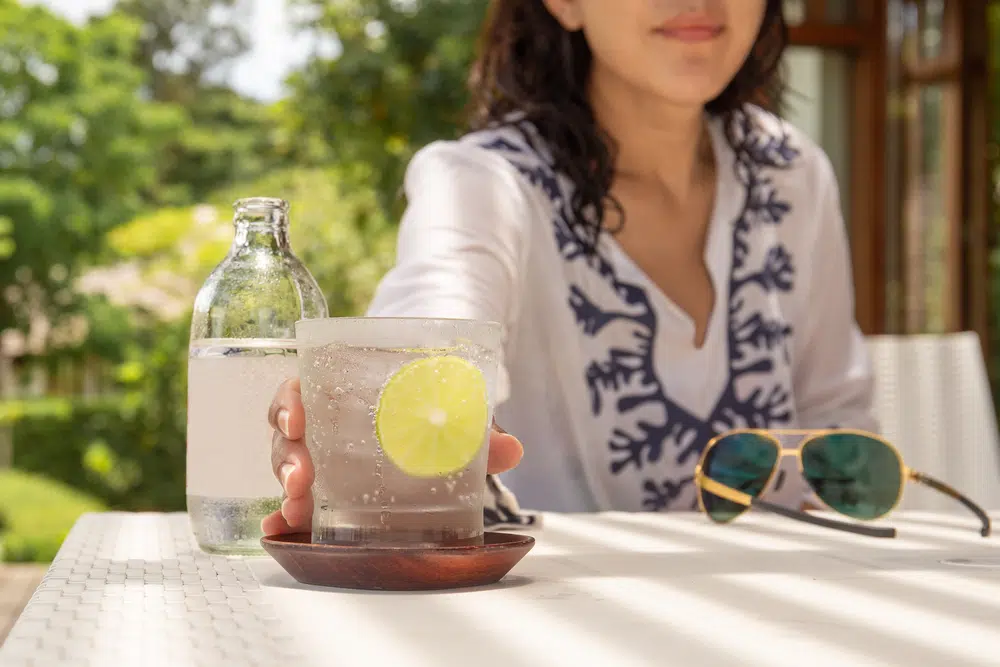 Woman Hand Reaching Glass Of  Sparkling Water