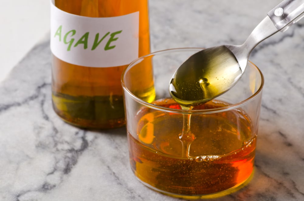 Pouring Agave Syrup On Glass With A Spoon