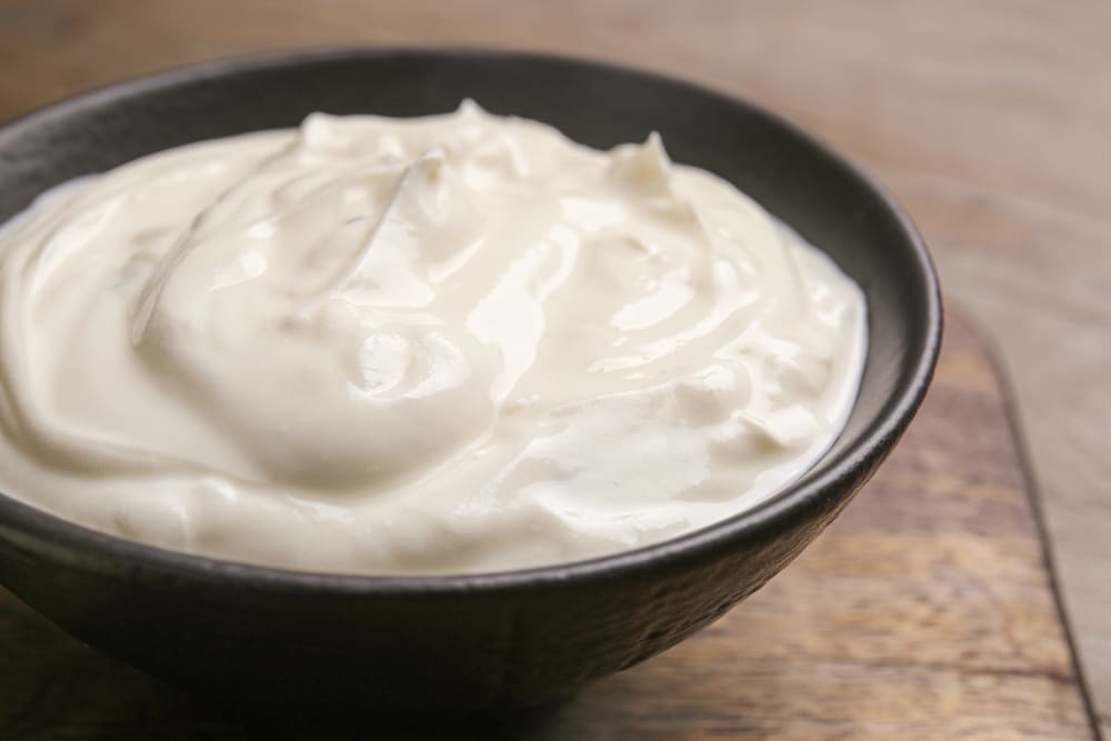 Closeup Of A Bowl Of Tasty Sour Cream On A Wooden Table