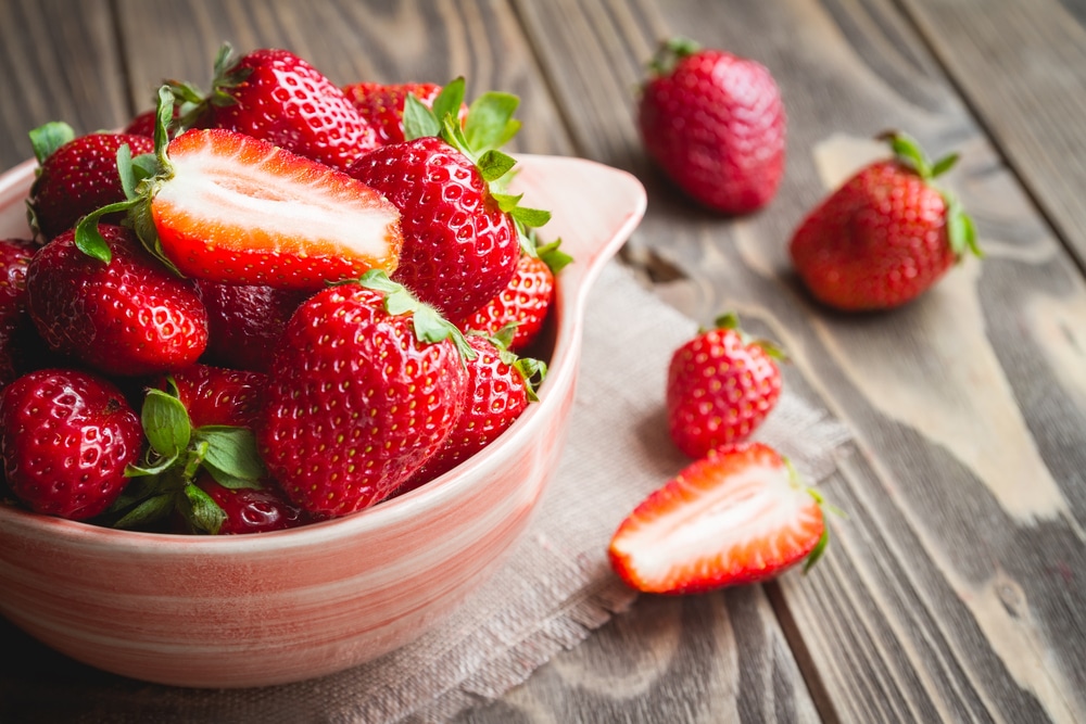 Fresh Strawberries In A Bowl On A Wooden Table